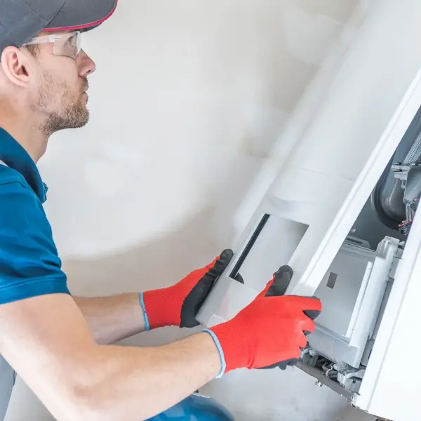 man performing maintenance on furnace