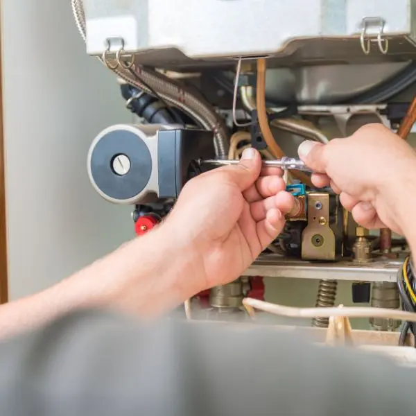 close up of man working on furnace components